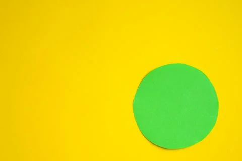 A green bright circle on a yellow background. Space copy. The embodiment of Stock Illustration