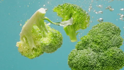 Green broccoli falling in boiling water, fresh fruits and vegetables falling Stock Footage 266762891