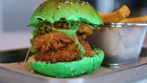 Green bun Grilled Beef Burger with Melted Cheese and Fresh Vegetables on a Stock Footage 317701899