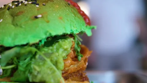 Green bun Grilled Beef Burger with Melted Cheese and Fresh Vegetables on a Stock Footage 317717111