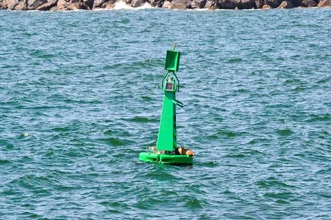 Green Buoy with Solar Panel and Light in Choppy Coastal Waters Stock Photos