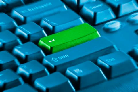 Green button on a blue keyboard Stock Photos