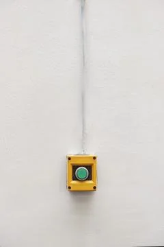 Green button installed for push start or stop machine isolated on white wall Stock Photos