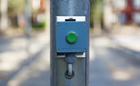 A green button mounted on a lamppost Stock Photos