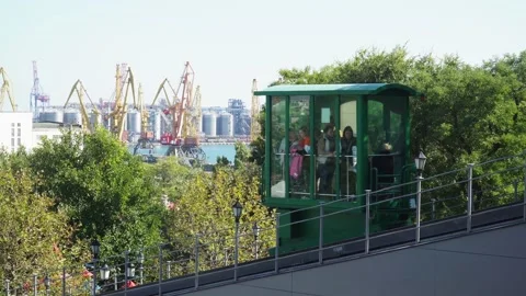 Green cable car rises with people on the background of the port Vidéo 163352228