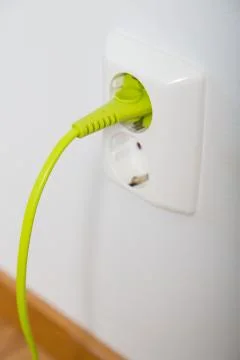Green cable in a grounded wall plug Фото