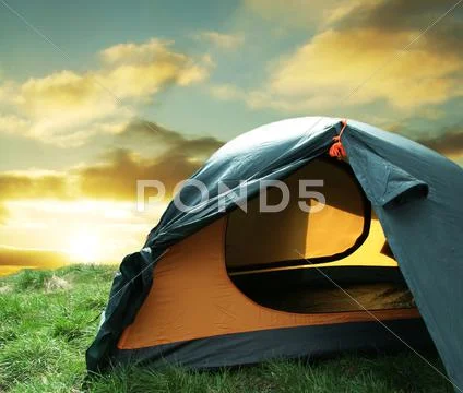 Green camping tent on sunny grassland Stock Photos
