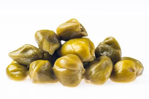 Green capers stacked on a white background in a simple arrangement Фото