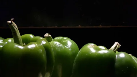 Green capsicums in the dark with light falling on them Stock Footage 128200226