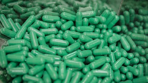 Green capsule pills falling in the pharmaceutical dust collecting machine Stock Footage 102459984