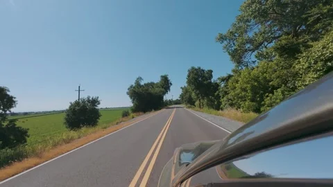 Green car driving down tree lined road in slow motion Stock Footage 309600033