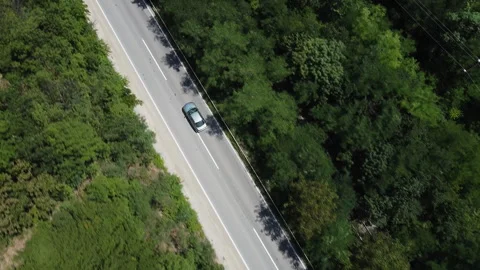 A green car is driving on a highway through nature. Aerial tracking shot Stock Footage 286255743