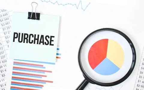 Green card on the white notepad and magnifier on the financial documentation. Stock Photos