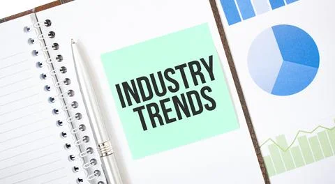 Green card on the white notepad. Text INDUSTRY TRENDS. Business concept Stock Photos