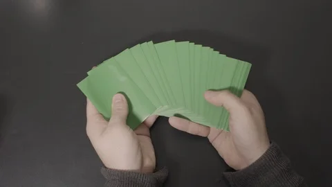 Green Cards Displayed in Hands then Straightened Stock Footage 100558644