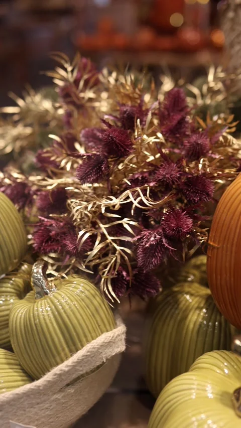 Green ceramic pumpkins with metallic stems and autumn flowers for stylish Hallow 库存影片 346973811