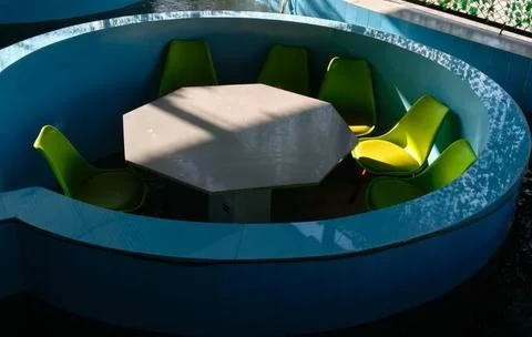 Green chairs and octagonal table Stock Photos