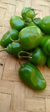 Green Chilies on Bamboo Surface Stock Photos