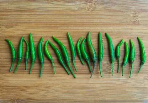 Green chilli pepper on chopping block Stock Photos