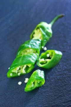 Green chilli peppers on the black table Stock Photos