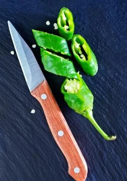 Green chilli peppers on the black table Stock Photos