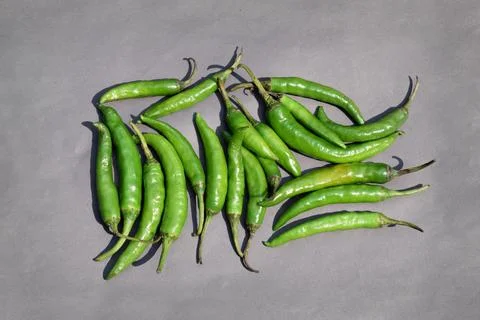 Green Chilli spice vegetables on gray background Stock Photos