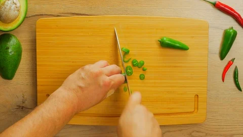Green chilly pepper cutting on a board Stock Footage 107538863