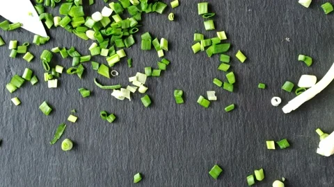 Green chopped onions fall onto the tabletop. Cooking salad with fresh herbs. 動画素材 149002838