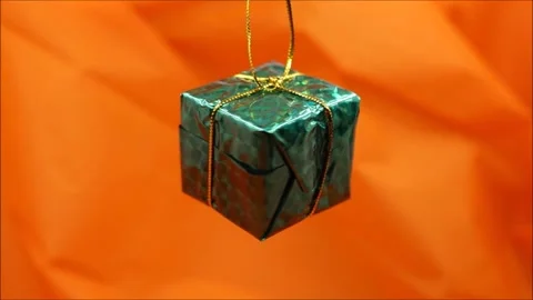 Green Christmas gift on orange background Stock Footage 167635113