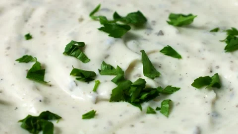 Green cilantro leaves falling down on garlic cilantro dipping sauce Video stock 278403364