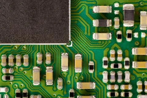 A green circuit containing a black microprocessor and various components. Foto stock