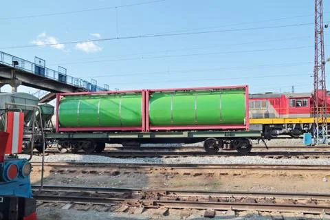 Green cistern of freight train at railway station with many electric wires at Stock Photos
