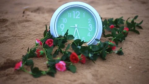 Green clock spining on the the brown sandy Stock Footage 94018427