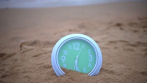 Green clock spining on the the brown sandy Stock Footage 94018455
