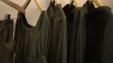 Green clothes hanging on the rack Stock Footage 259787215