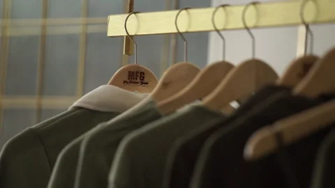 Green clothes hanging on the rack Stock Footage 259787330