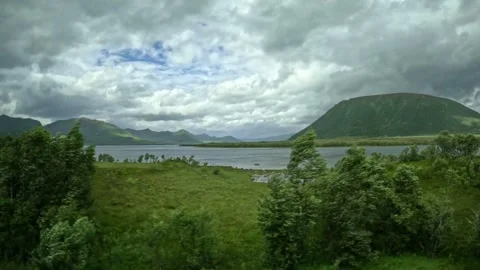 Green coastal meadow and rounded mountain near fjord in Andoya Norway Vidéo 343379918