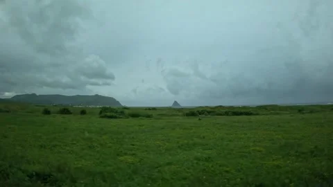 Green coastal meadows with distant Bleik village and Bleiksoya island in Norway 스톡 동영상 343131122