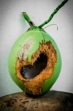 Green coconut with hole on table Stock Photos