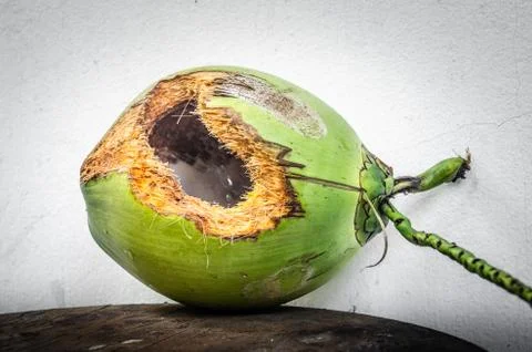 Green coconut with hole on table Stock Photos
