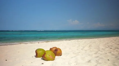 Green coconuts on the white sand of the turquoise sea beach. Amazing vacation in Stock Footage 233593154