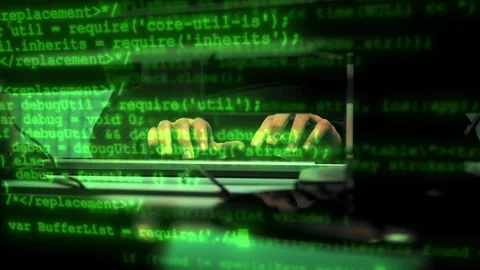 Green code characters running infront of typing haker's hands in a dark office Stock Footage 120403451