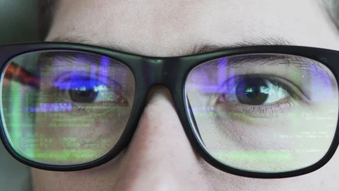 Green coding or hacking text is reflecting in the glasses static shot Stock Footage 108751877