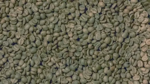 Green coffee beans pouring into roaster Stock Footage 69937109