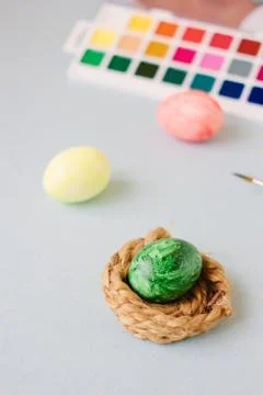 Green color easter egg in small nest over bright background Stock Photos