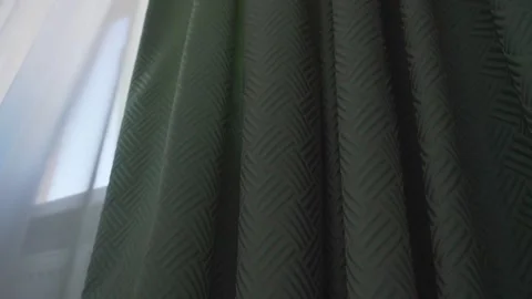 Green colored dense fabric drape hanging on window cornice Stock Footage 164232122