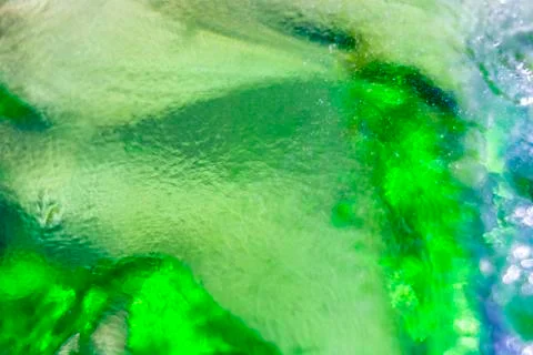 A green colored glass from a bottle sifting the light Foto stock