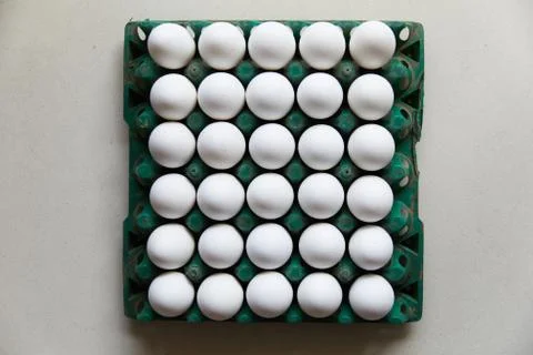 A green colored plastic egg crate with 30 white eggs Stock Photos
