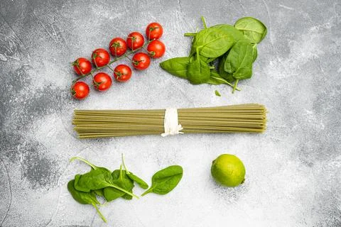 Green colored spaghetti raw dry spinach, on gray stone table background, top Stock Photos