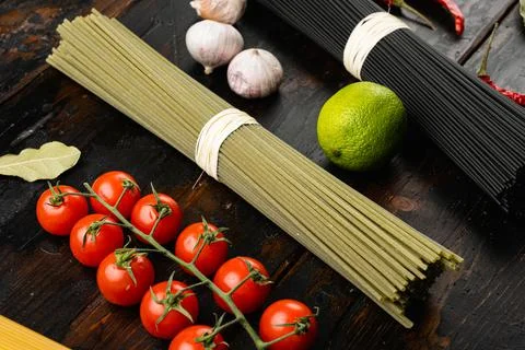 Green colored spaghetti raw dry spinach, on old dark wooden table background Stock Photos